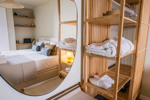 a mirror in a bedroom with a bed at Zus House Stylish Pool Stay Near Lisbon & Beach in Parede
