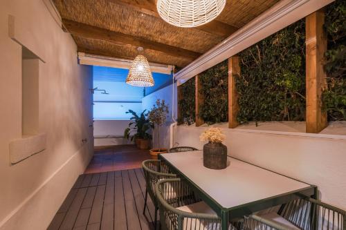 a patio with a table and chairs and a light fixture at Zus House Stylish Pool Stay Near Lisbon & Beach in Parede