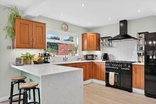 a kitchen with wooden cabinets and a black appliance at Central Belfast Apartments Rosetta Residence in Belfast