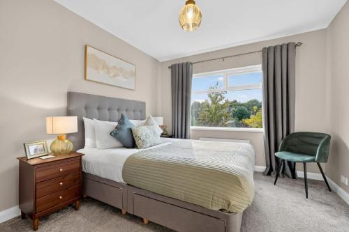 a bedroom with a bed and a green chair at Central Belfast Apartments Rosetta Residence in Belfast