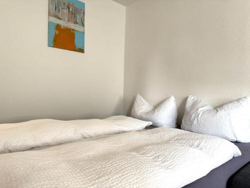 a bed with white sheets and pillows in a room at Jasmina Appartments in Jenbach