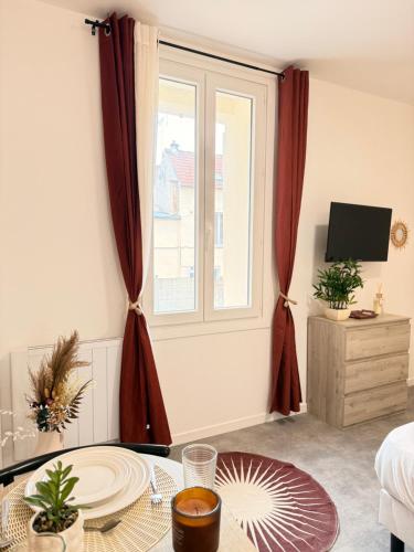 a living room with a table and a window at Studio Rosa - Disney - Meaux City Center - Paris in Meaux