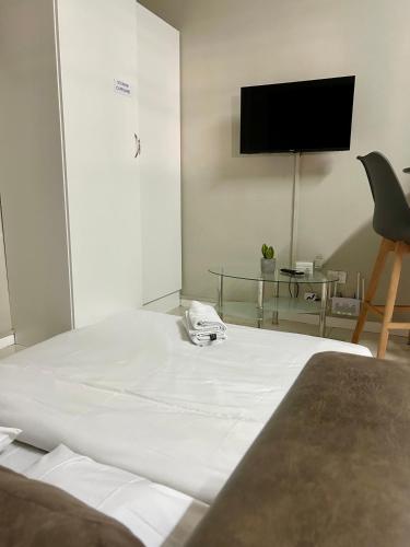 a bedroom with a white bed with a tv on the wall at Meridian Suite Apartments in Umhlanga Ridge in Durban