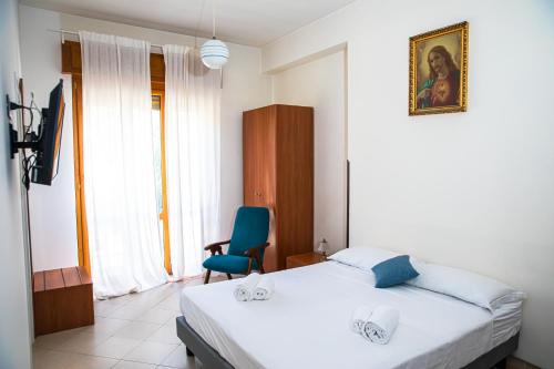 a bedroom with a bed and a blue chair at Palazzo Durante in Letojanni