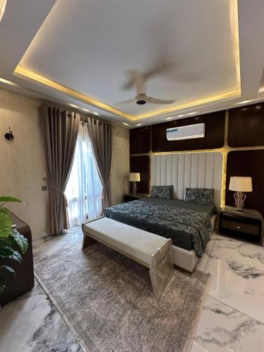 ein Schlafzimmer mit einem Bett und einem großen Fenster in der Unterkunft 5 bed room luxury villa in DHA phase 8 in Lahore