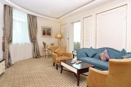 a living room with a blue couch and chairs at Gewan Hotel Cairo in Cairo