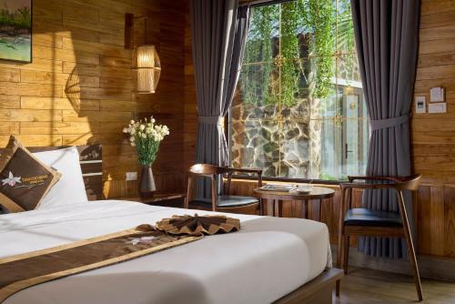 a bedroom with a bed and a large window at Tam Coc Orchid Hotel & Spa in Ninh Binh
