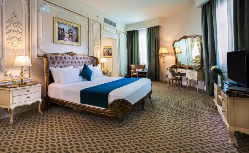 a bedroom with a king sized bed and a mirror at Gewan Hotel Cairo in Cairo