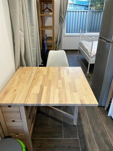 a wooden table in a room with a crib at Modern Granny Flat with Private Patio in Belmore in Sydney