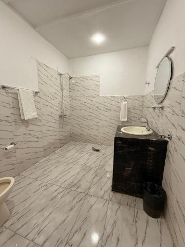 a white bathroom with a sink and a toilet at Nestopia Islamabad in Islamabad