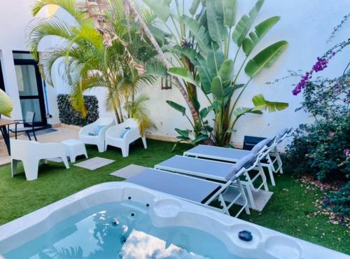 a backyard with a pool and chairs and a swimming pool at Villa Cleo, vistas de ensueño in San Miguel de Abona