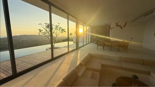 a living room with a couch and a table on a balcony at Anzhu Seamate Villa Samui in Amphoe Koh Samui
