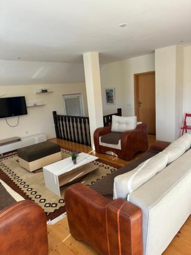 a living room with leather furniture and a tv at Villa Kalin Kamen in Kriva Palanka