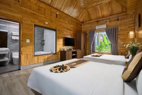 a bedroom with two beds and a television in it at Tam Coc Orchid Hotel & Spa in Ninh Binh