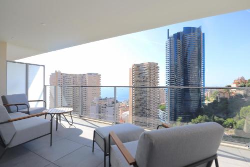 a balcony with chairs and a view of a city at Sun Paradise SeaView&Terrace Parking&Pool in Beausoleil