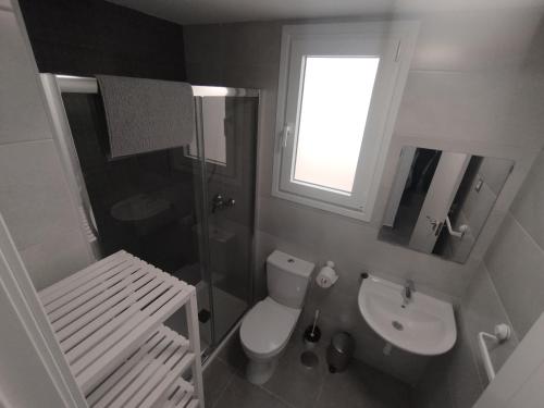 ein Badezimmer mit Toilette und Waschbecken und einem Fenster in der Unterkunft Velez Malaga 2 Dorm 4 Huésped Piscina Parking WiFi in Vélez-Málaga