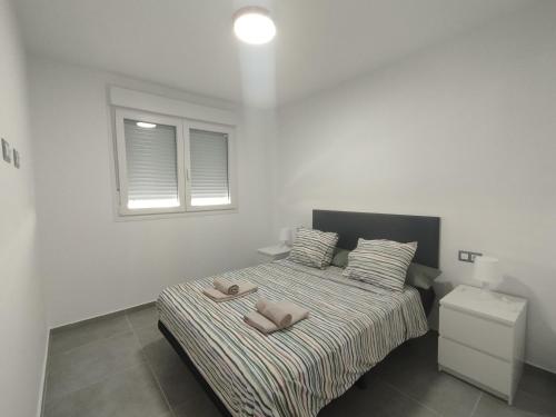 ein Schlafzimmer mit einem Bett mit zwei Handtüchern darauf in der Unterkunft Velez Malaga 2 Dorm 4 Huésped Piscina Parking WiFi in Vélez-Málaga