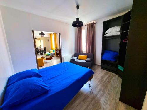 une chambre avec un lit bleu et un salon dans l'établissement Loft décoration Seventies, à Elbeuf