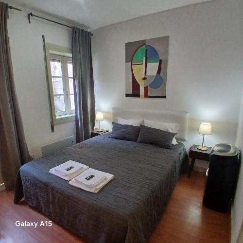 Un dormitorio con una cama con dos toallas encima. en Villa Regio Studio & Garden, en Vila do Conde