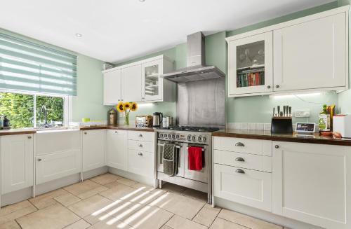 a kitchen with white cabinets and a stove at Leamington Spa Warwick Place Apartments in Leamington Spa