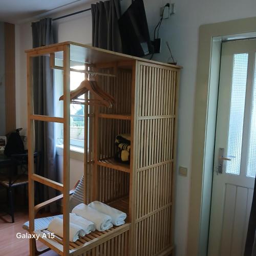 a room with a wooden book shelf with towels at Villa Regio Studio Kitchen & Garden in Vila do Conde