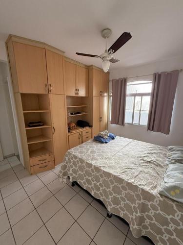 una camera da letto con un letto e un ventilatore a soffitto di Apartamento em prédio na Praia do Morro a Guarapari