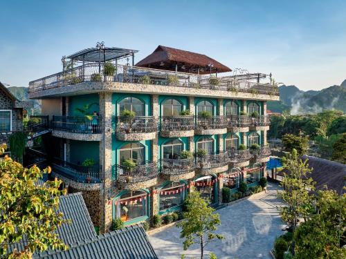 a large building with balconies and trees in front of it at Tam Coc Orchid Hotel & Spa in Ninh Binh
