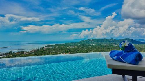 a stuffed animal sitting on a table next to a swimming pool at Anzhu Seamate Villa Samui in Amphoe Koh Samui