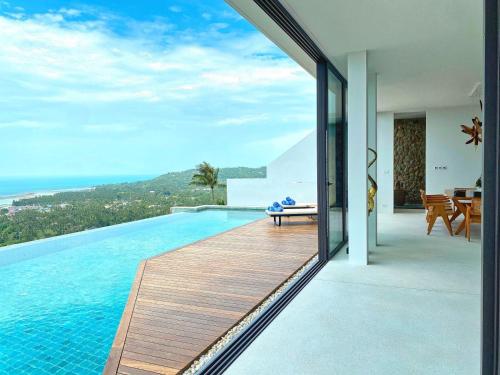 a pool with a view of the ocean from a house at Anzhu Seamate Villa Samui in Amphoe Koh Samui