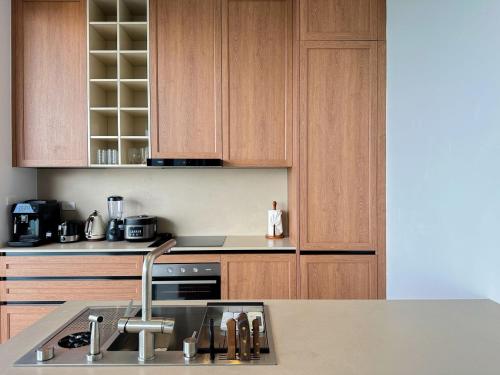 a kitchen with wooden cabinets and a sink and a stove at Anzhu Seamate Villa Samui in Amphoe Koh Samui