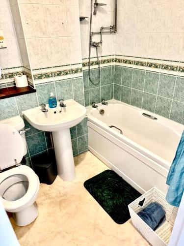 a bathroom with a toilet and a tub and a sink at Modern 2BR Stay FREE WIFI FREE PARKING in Great Linford