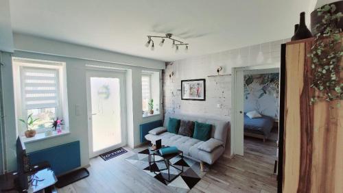 a living room with a couch and two windows at Le ptit Cosy appartement privatif in Bining-lès-Rohrbach