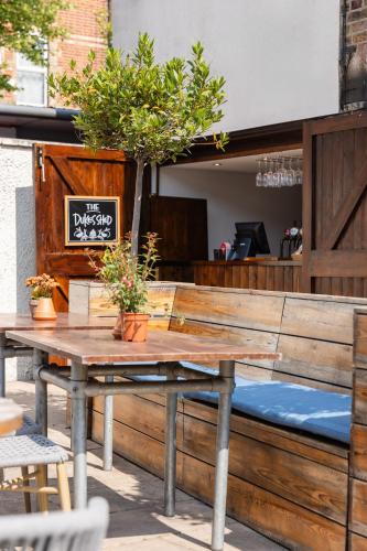 a wooden table with potted plants on a patio at Dukes Head Hotel in Croydon