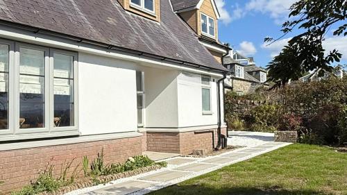 ein Haus mit einem Fenster an der Seite in der Unterkunft Bramble Cottage in Criccieth