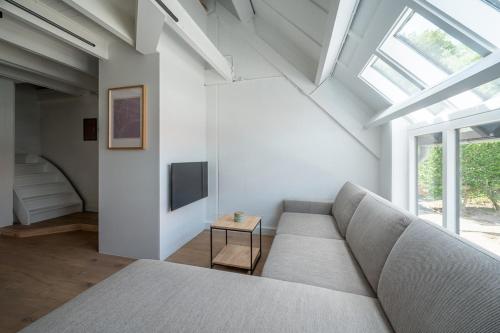 Una sala de estar con un sofá y una ventana. en Casa Azul, en Nieuwpoort