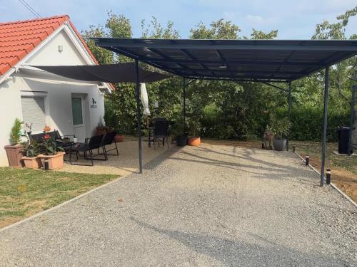 un patio con una tettoia nera davanti a una casa di Small cottage guest house a Pécsvárad