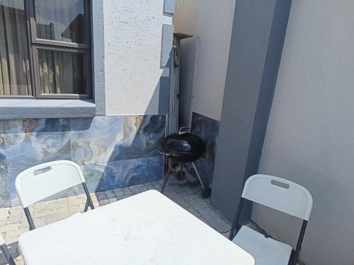 a table and two chairs in a room with a wall at Classy Guest House in Johannesburg