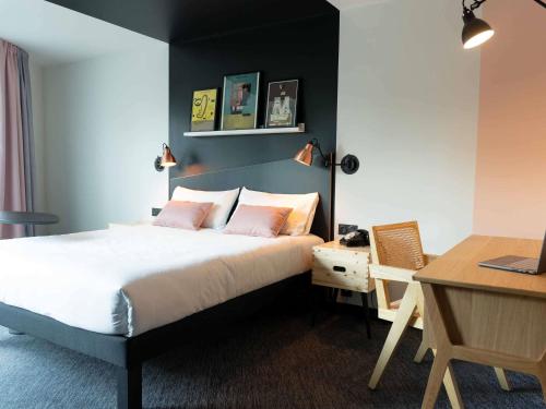 a bedroom with a bed and a desk with a laptop at ibis Styles Dreux Centre Gare in Dreux