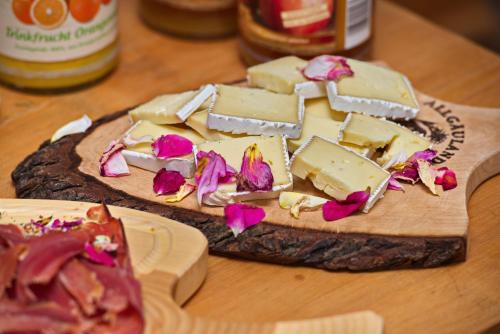 two slices of cheese on a wooden cutting board at Allgäuer Panoramahotel in Oberstaufen
