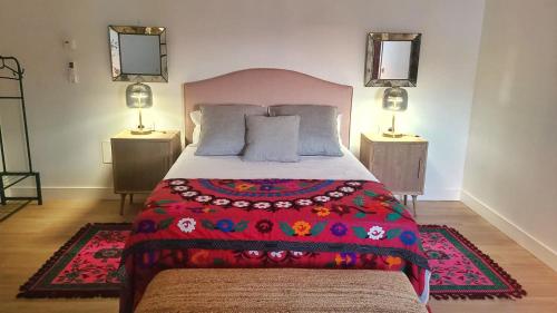 a bedroom with a large bed with a red blanket at Cortijo Negretti in Herrera de Alcántara