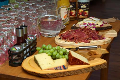 a table with cheese and grapes and glasses of wine at Allgäuer Panoramahotel in Oberstaufen