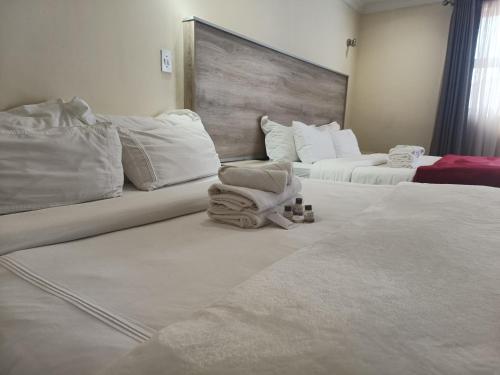 a hotel room with two beds with white sheets at Classy Guest House in Johannesburg