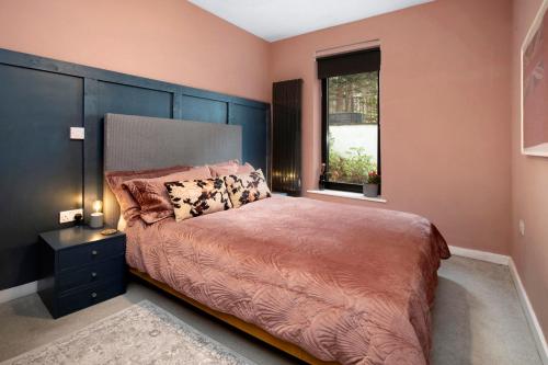 a bedroom with a large bed and a window at Pinewood Lodge in South Brent