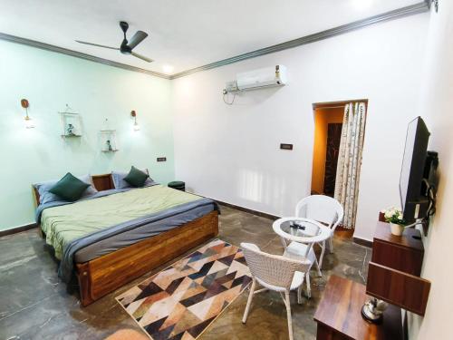 a bedroom with a bed and a table and chairs at Prajay Inn in Yelagiri