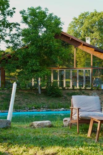 a chair sitting in the grass next to a pool at Eko Zaseok Brana in Rekovac