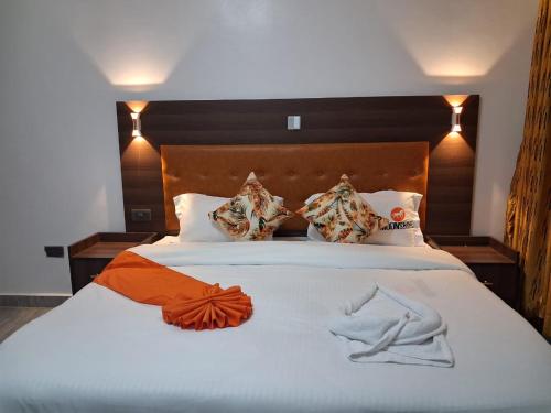 une chambre avec un grand lit blanc avec des oreillers dans l'établissement Moonshine walkers furnished apartments, à Naivasha