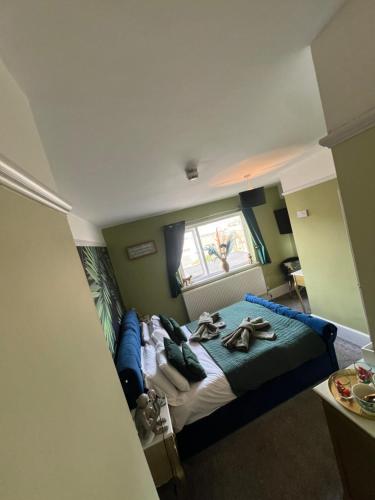 a bedroom with a large bed with a blue bed frame at The Butterfly Guest House in Porthcawl