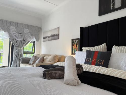 a bedroom with a large bed and a couch at Dainfern Cosy Condo in Midrand