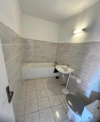 ein Badezimmer mit Badewanne, Toilette und Waschbecken in der Unterkunft Ti Kay soléy in Bouillante