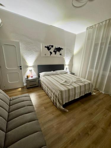 ein Schlafzimmer mit einem Bett und einer Couch in der Unterkunft Modern Home near Hospital and City Center in Parma